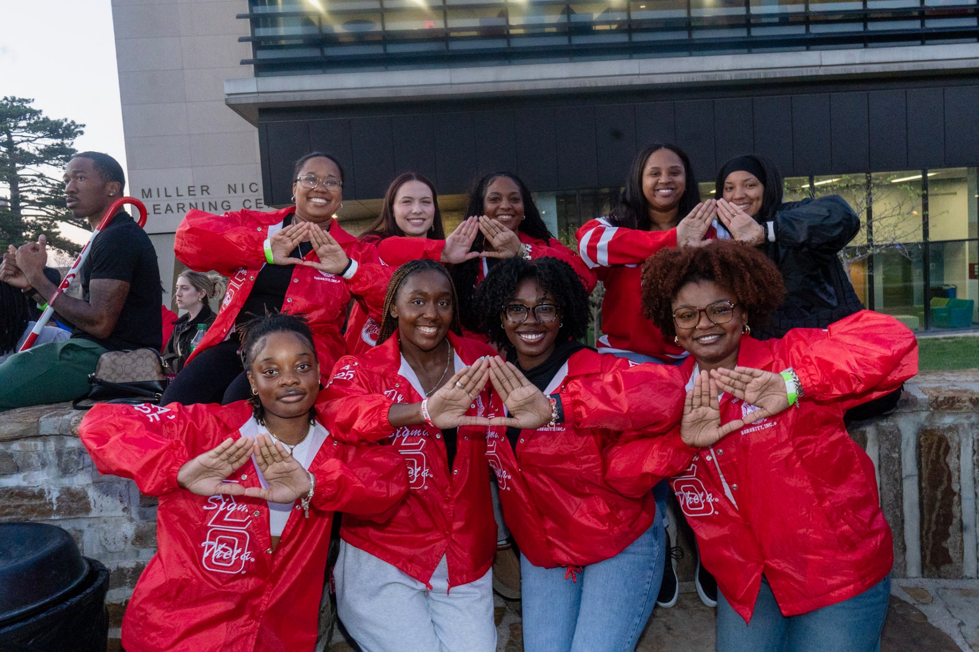 Lambda Epsilon chapter line outside Miller Nichols Learning Center